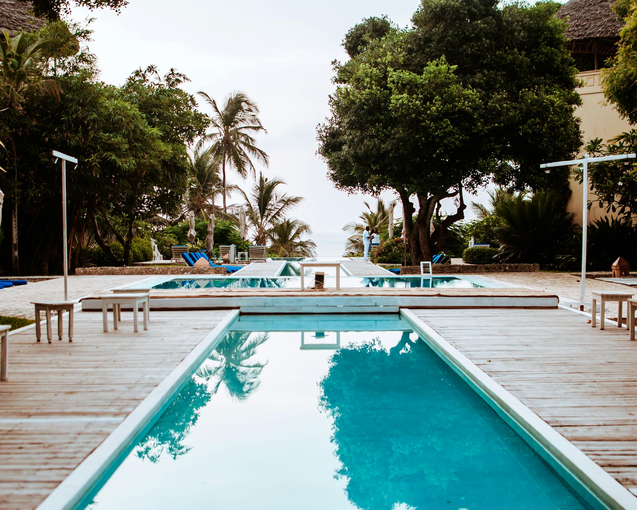Swimming pool on hotel terrace near tropical trees